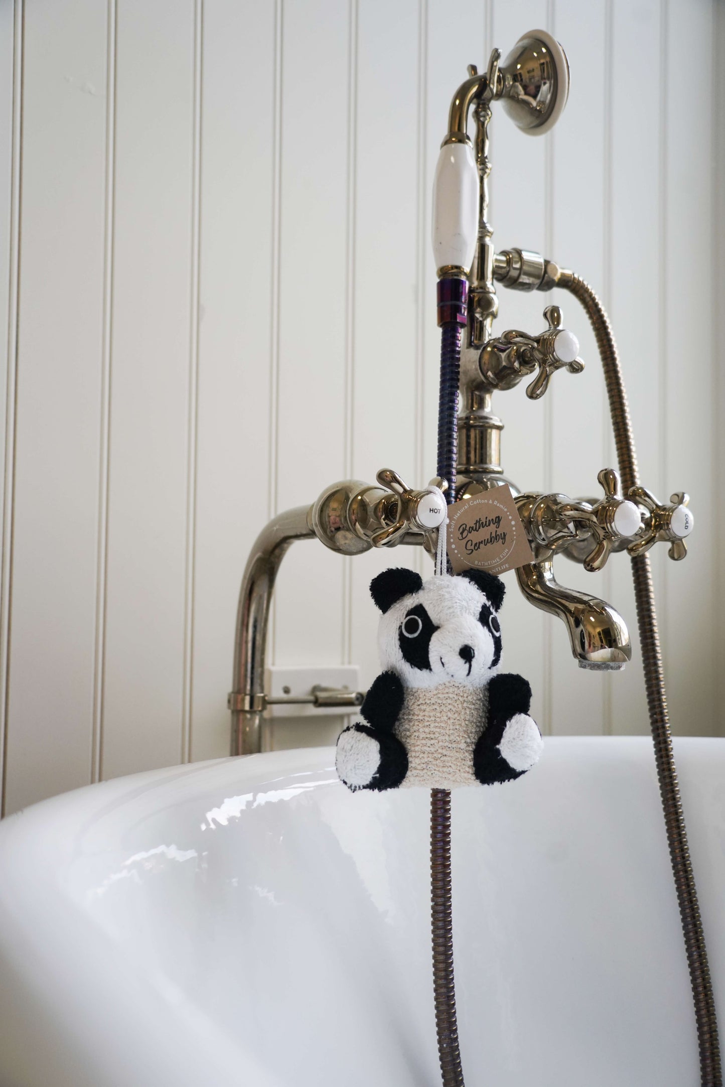 Panda-shaped bath toy hanging from a faucet in a bathroom setting