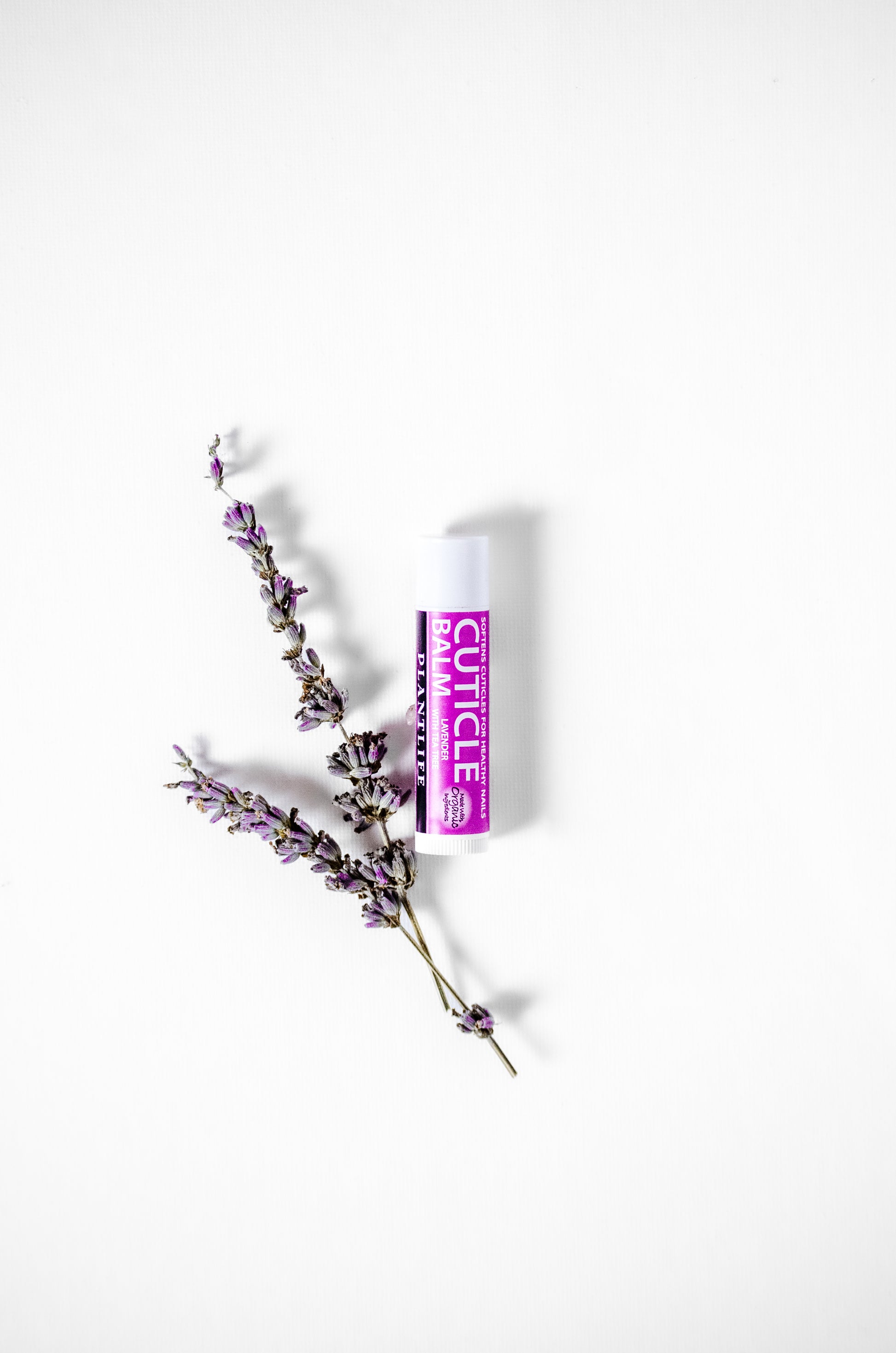 Plantlife Lavender Tea Tree Cuticle Balm styled with fresh lavender sprigs on a white background.