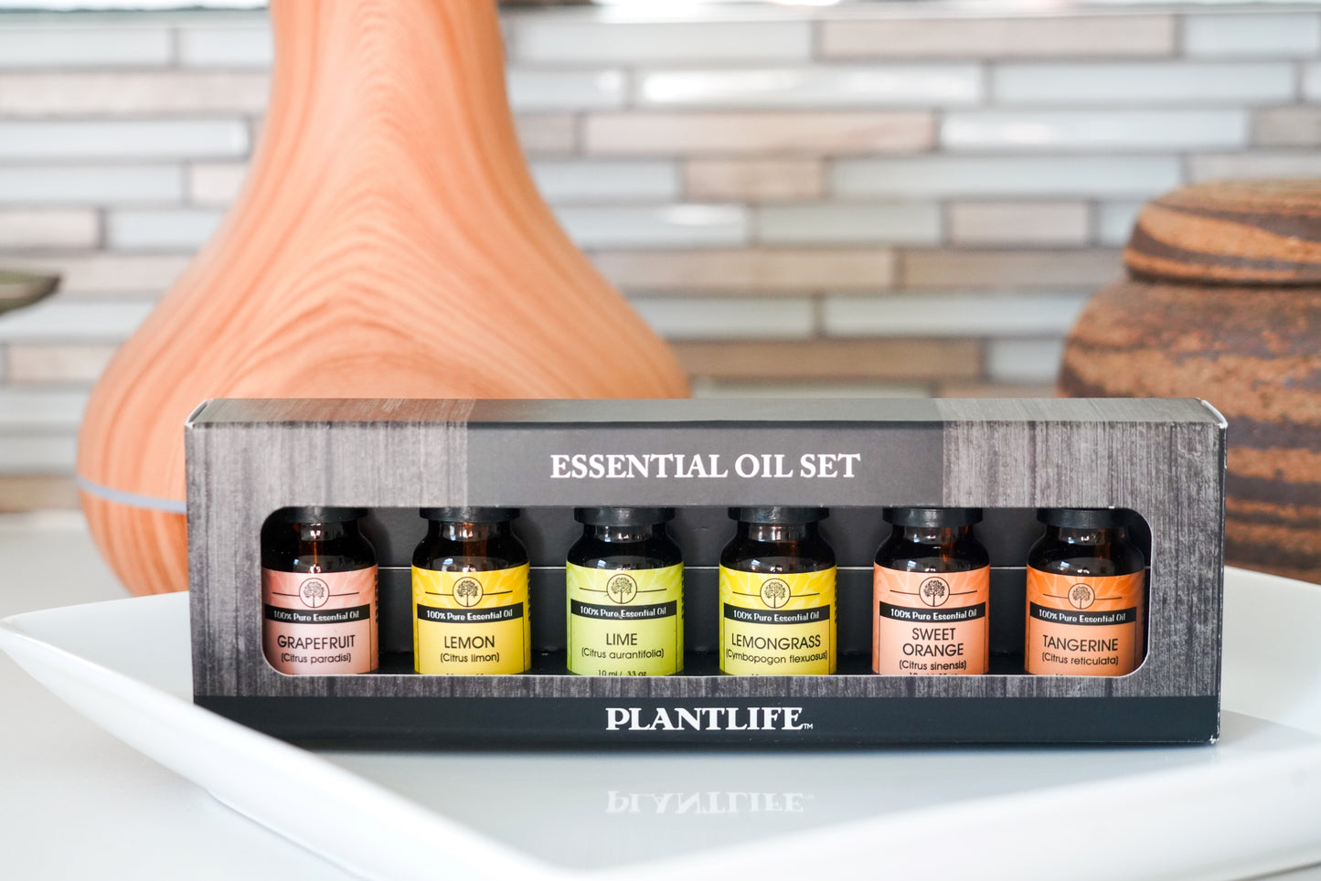 Set of essential oils in a box with 'Plantlife' branding on a table.