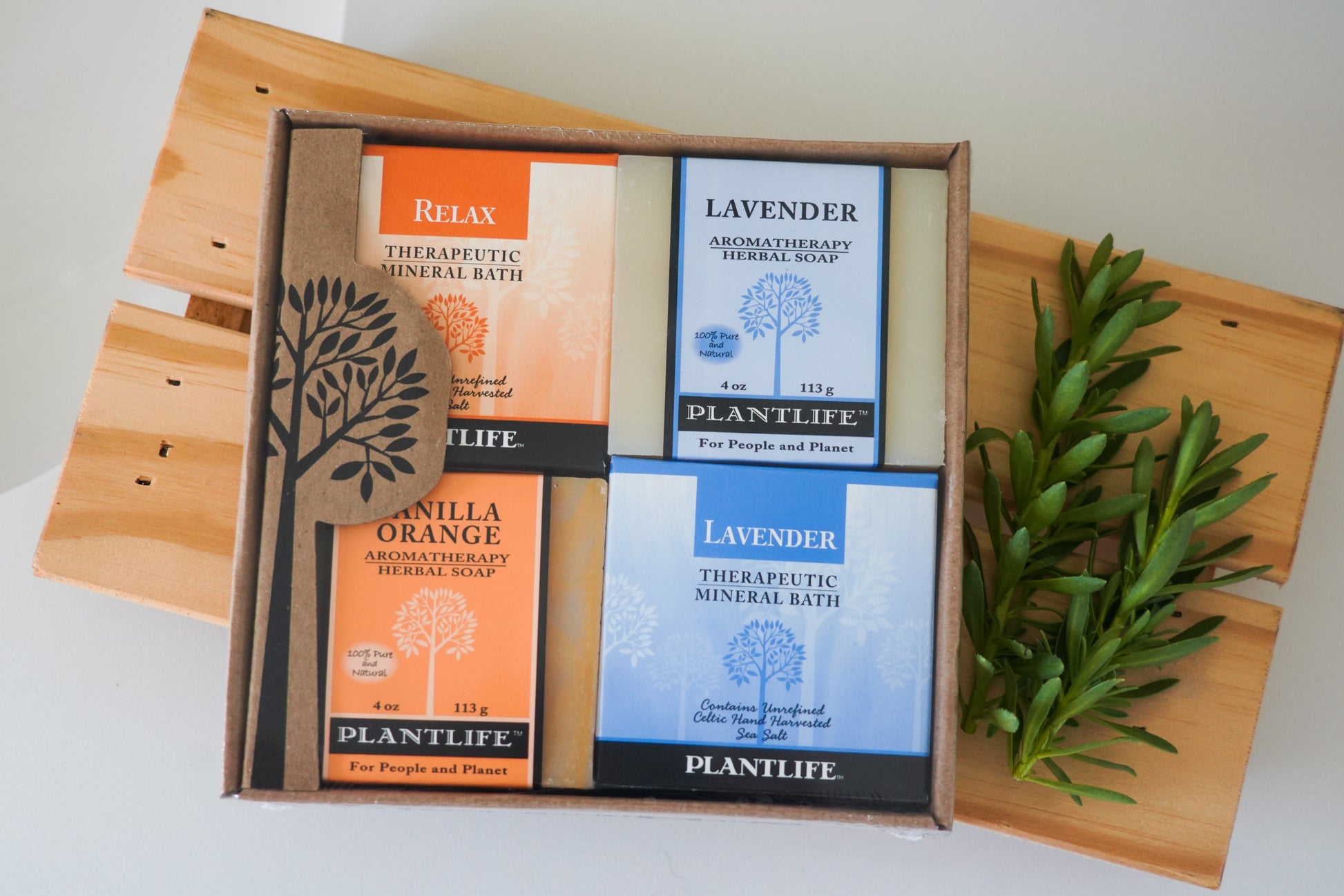 Plantlife bath salt packages on a wooden board with a plant.