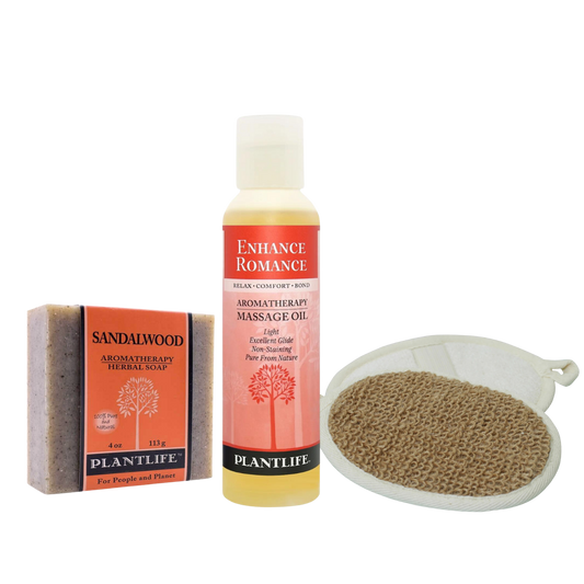 Plantlife Enhance Romance gift set featuring sandalwood aromatherapy soap, massage oil, and natural exfoliating heart-shaped bath mitt on transparent background