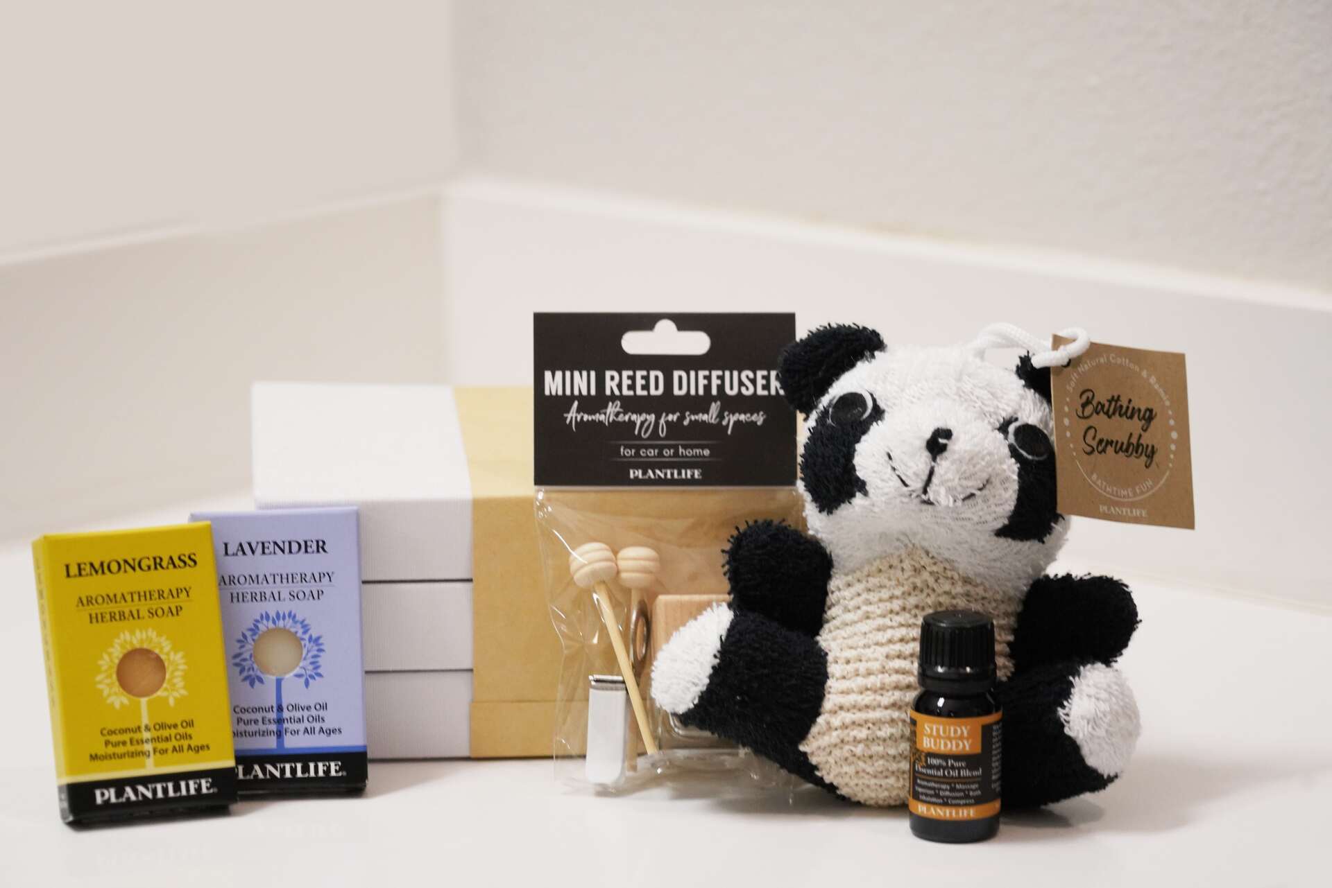Plantlife back-to-school aromatherapy gift set including Lemongrass and Lavender soap samples, Mini Reed Diffuser, Study Buddy essential oil, and a panda-shaped Bathing Scrubby displayed with a gift box.