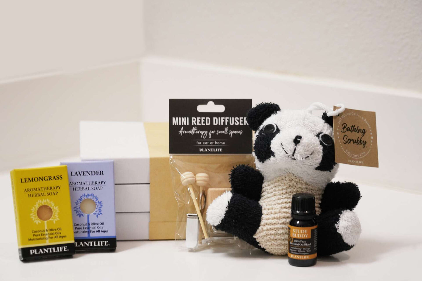 Plantlife back-to-school aromatherapy gift set including Lemongrass and Lavender soap samples, Mini Reed Diffuser, Study Buddy essential oil, and a panda-shaped Bathing Scrubby displayed with a gift box.