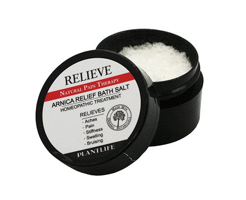 Open jar of Plantlife Relieve Arnica Relief Bath Salt showing coarse granules, designed for natural pain therapy to help relieve aches, stiffness, swelling, and bruising with organic botanicals.