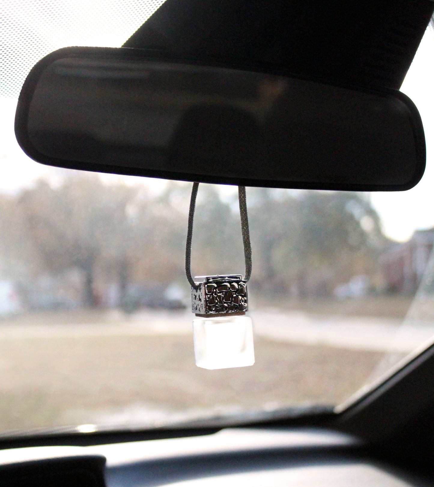 Silver Passive Diffuser from Plantlife hanging on rearview mirror – natural air freshener for cars or small spaces.