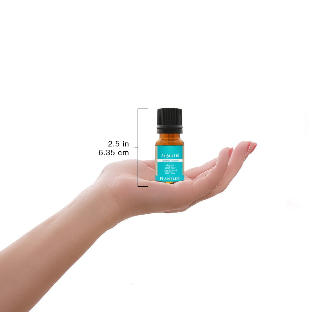 Argan Oil bottle held in hand for scale