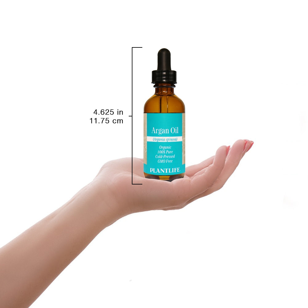 Argan Oil bottle held in hand for scale