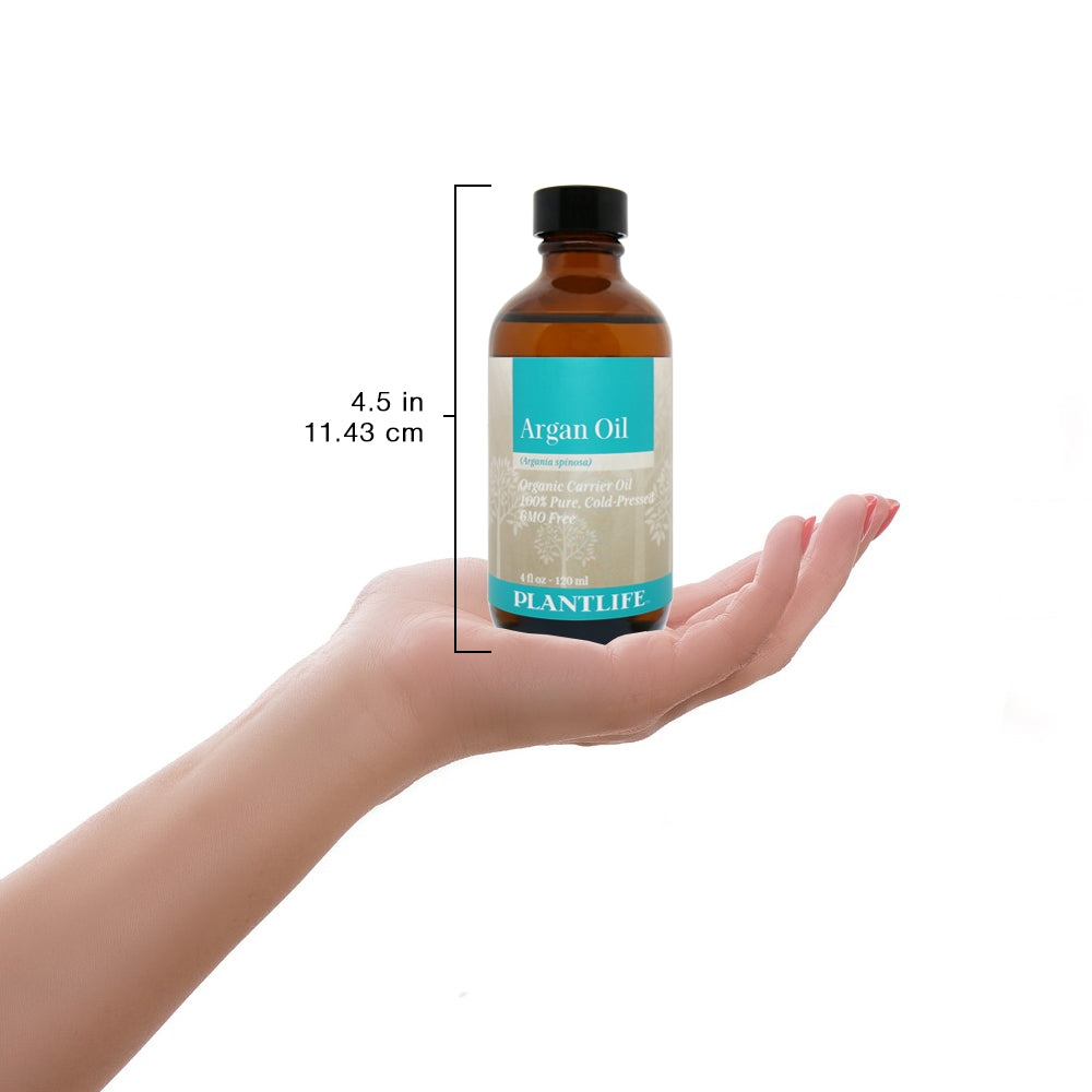Argan Oil bottle held in hand for scale