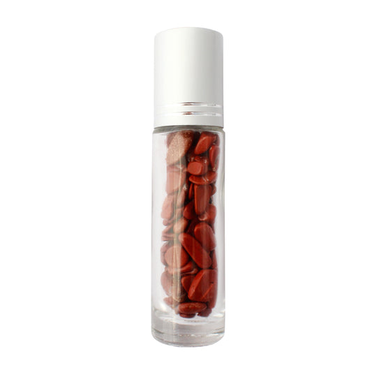 Clear glass essential oil roller bottle with a white cap, filled with polished red gemstone chips inside.