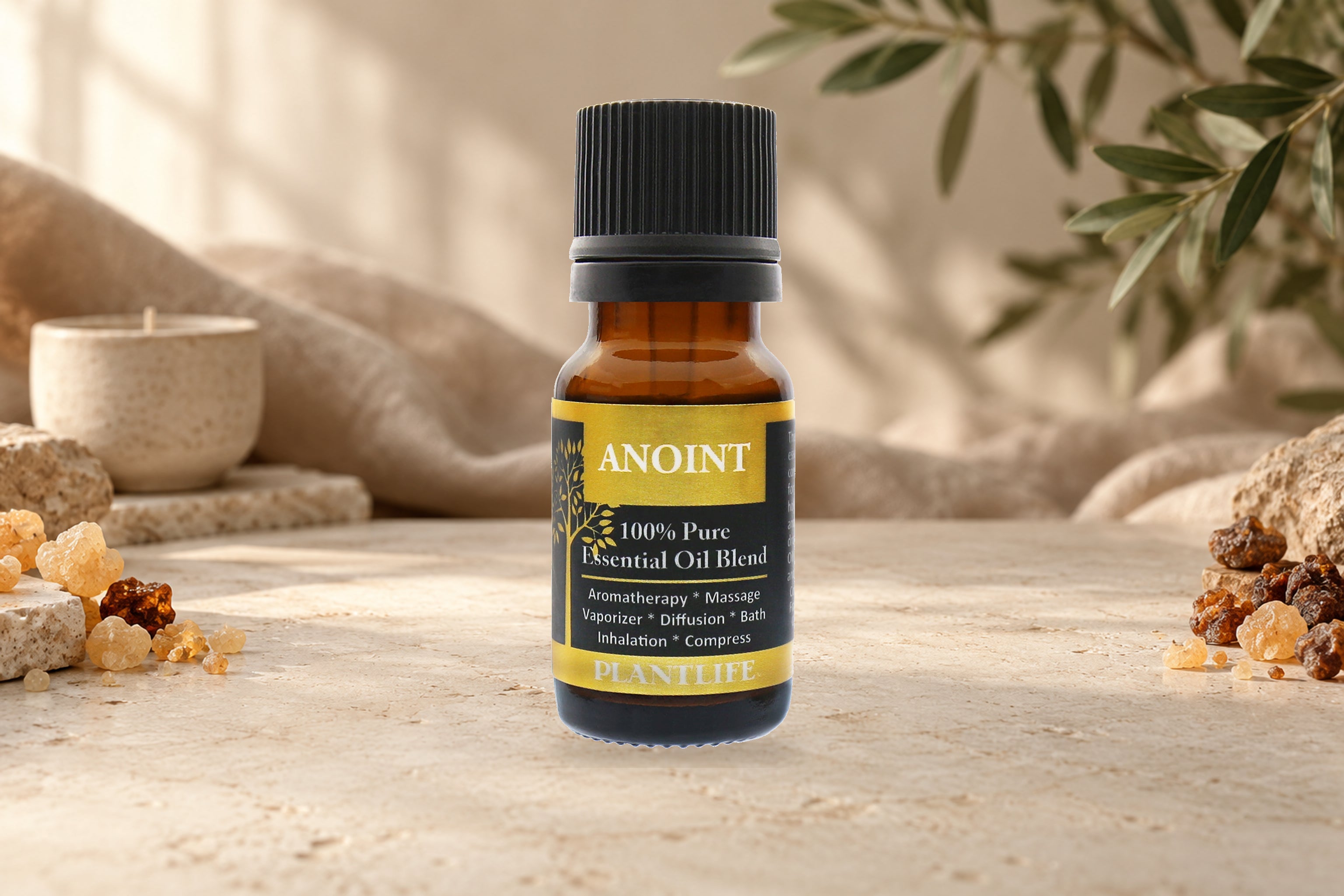 Plantlife Anoint Essential Oil Blend bottle on a stone surface with resin, linen, and soft greenery.