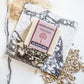 A rectangular bar of soap labeled 'ASHWAGANDHA' and 'PLANTLIFE' sits on a white marble slab, styled with dried botanicals on a white marble surface.