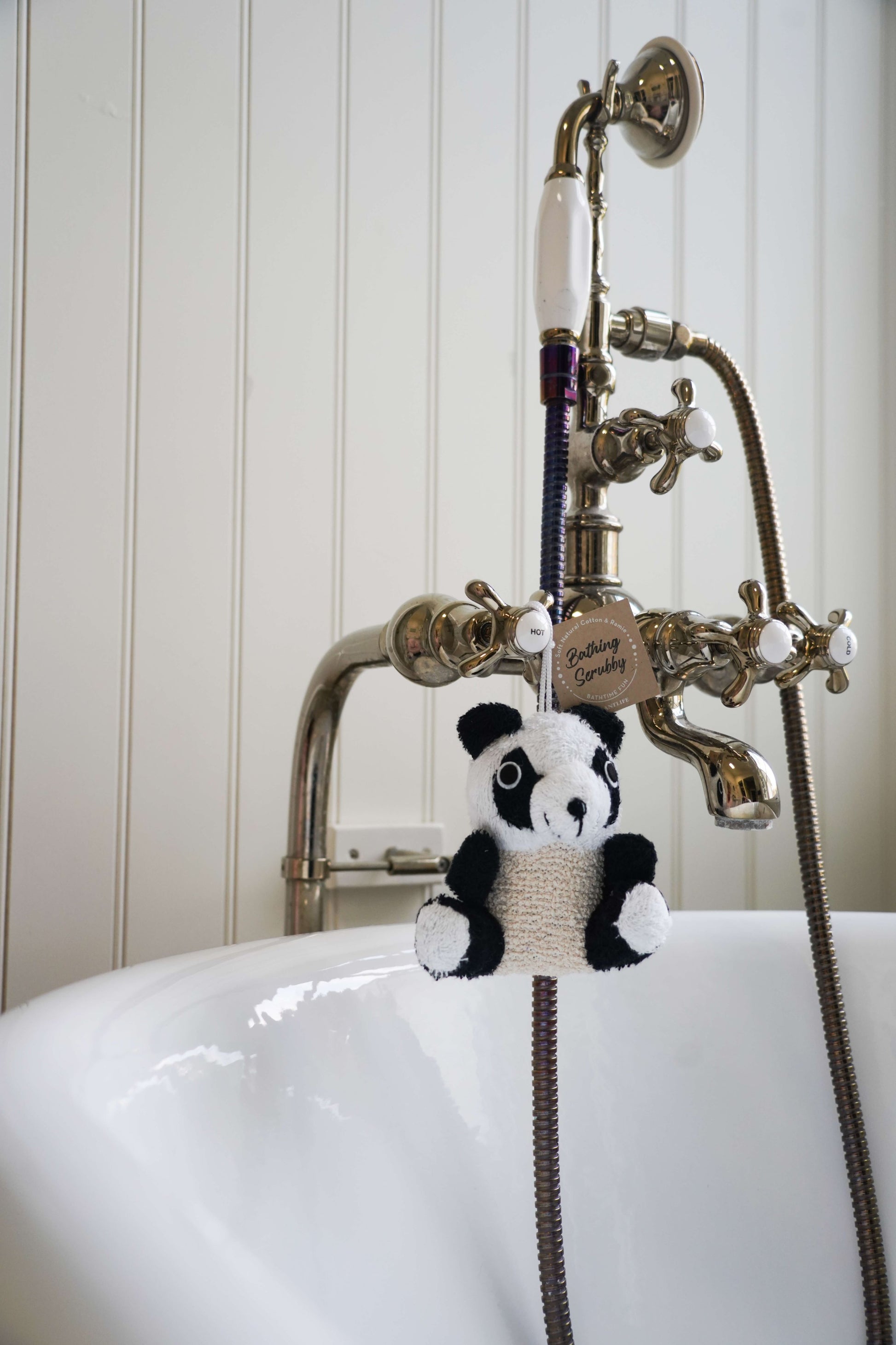 Panda-shaped bath toy hanging from a faucet in a bathroom setting