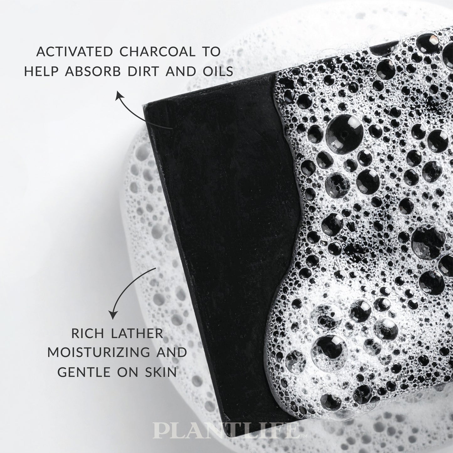 Close-up of a black Plantlife soap bar resting in foamy water. Text on the image highlights “Activated charcoal to help absorb dirt and oils” and “Rich lather, moisturizing and gentle on skin.”