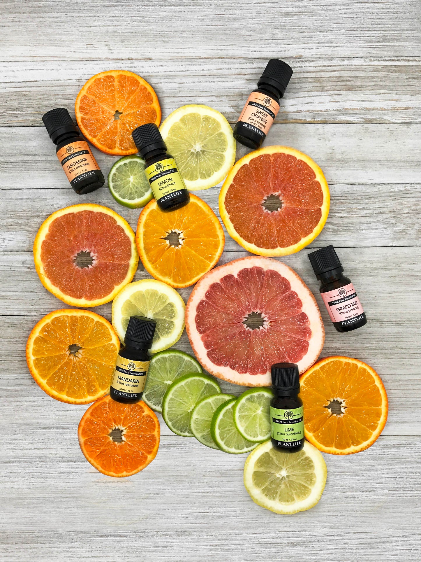 Essential oil bottles with citrus fruits on a wooden surface