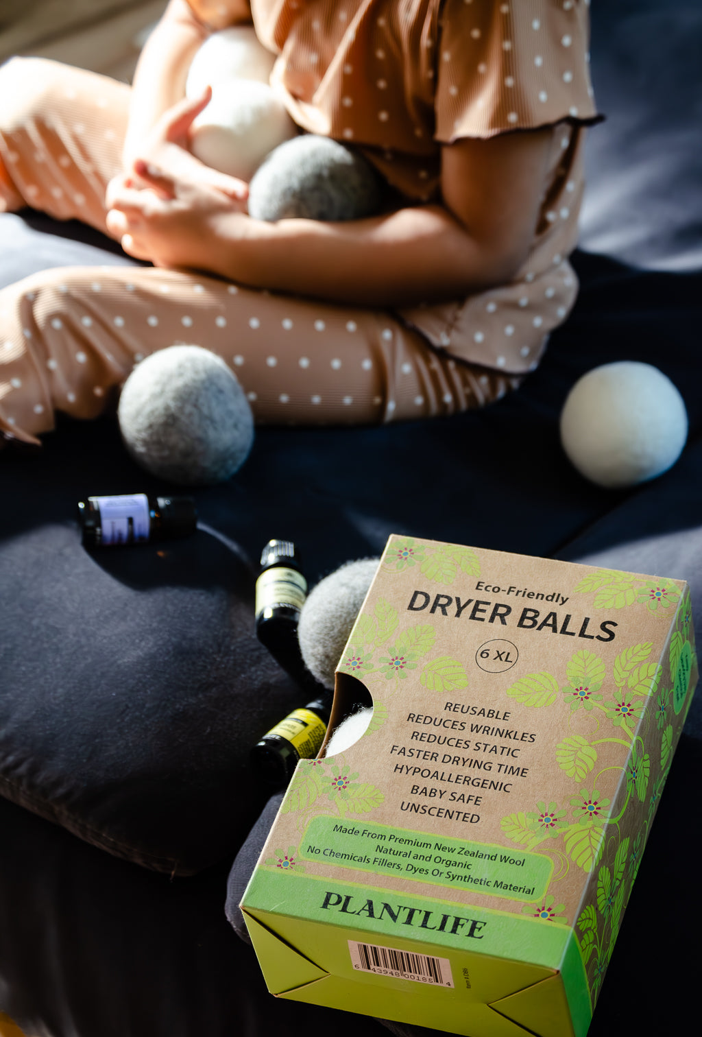 Box of Plantlife dryer balls with a person holding dryer balls in the background