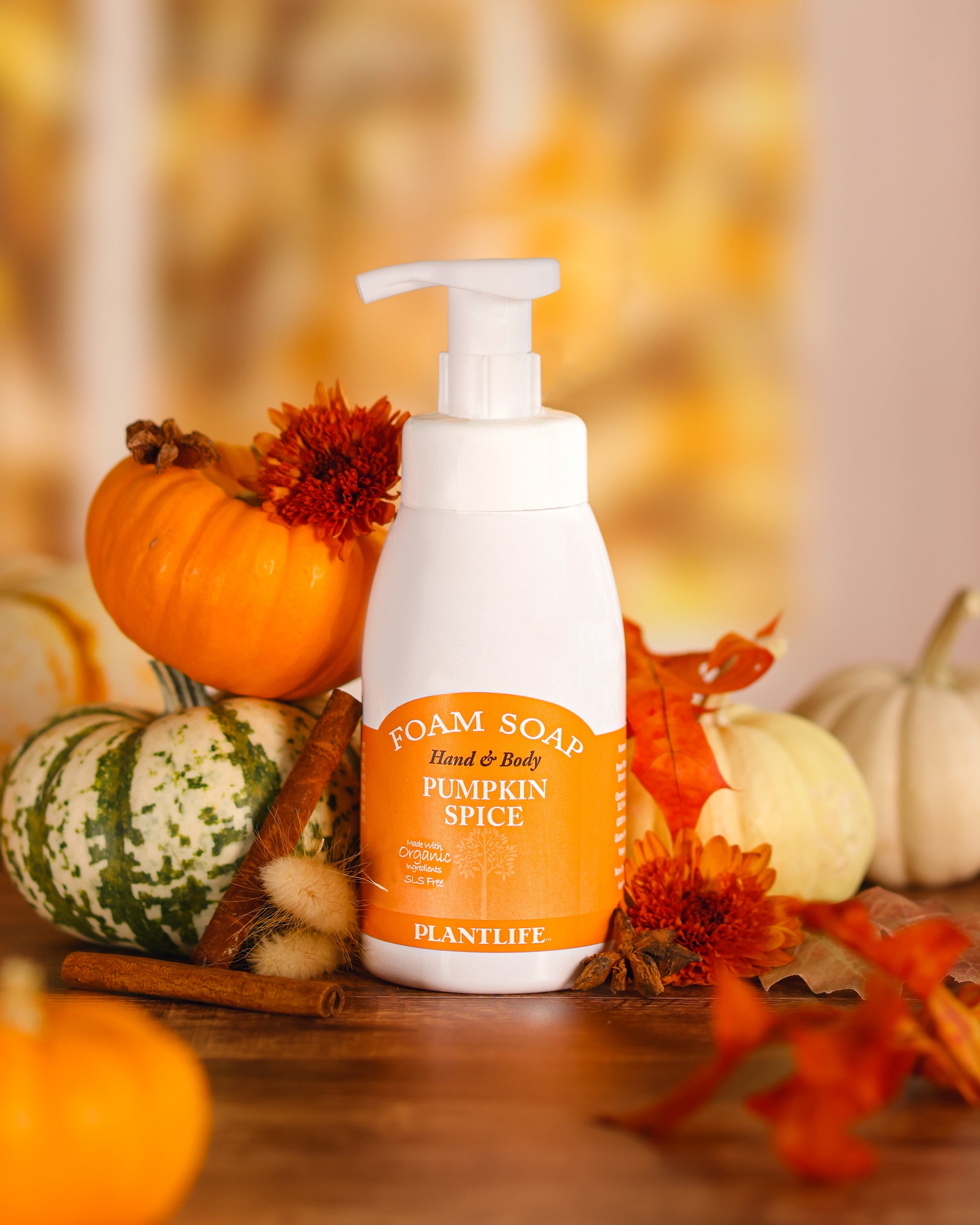 Foam soap bottle with pump labeled 'Pumpkin Spice' by Plantlife, surrounded by autumn decorations.