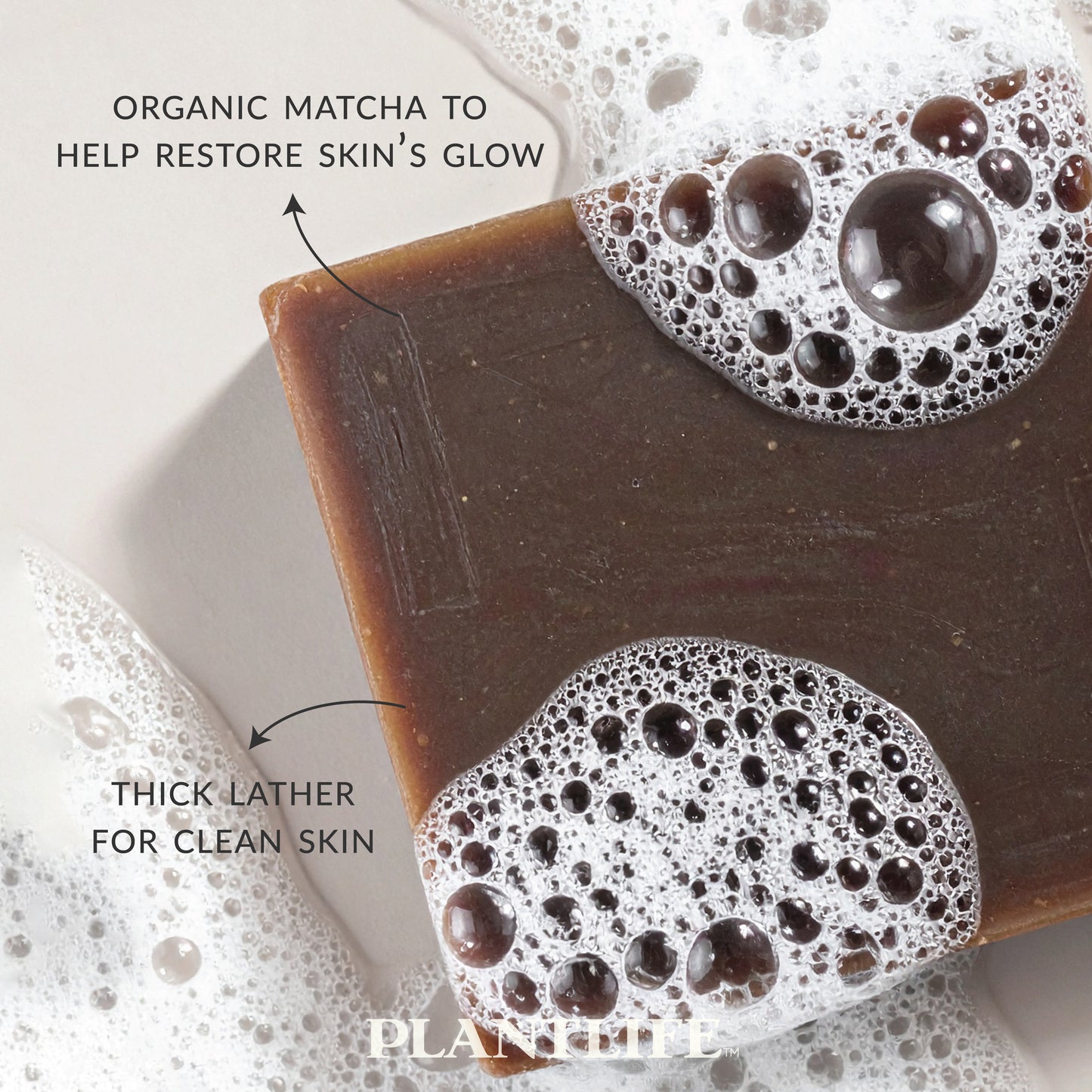 Close-up of Plantlife Matcha Soap bar with dark green hue and thick foam bubbles. Text reads “Organic matcha to help restore skin’s glow” and “Thick lather for clean skin.” Natural plant-based bar made with antioxidant-rich matcha to cleanse, nourish, and revitalize the skin’s appearance.