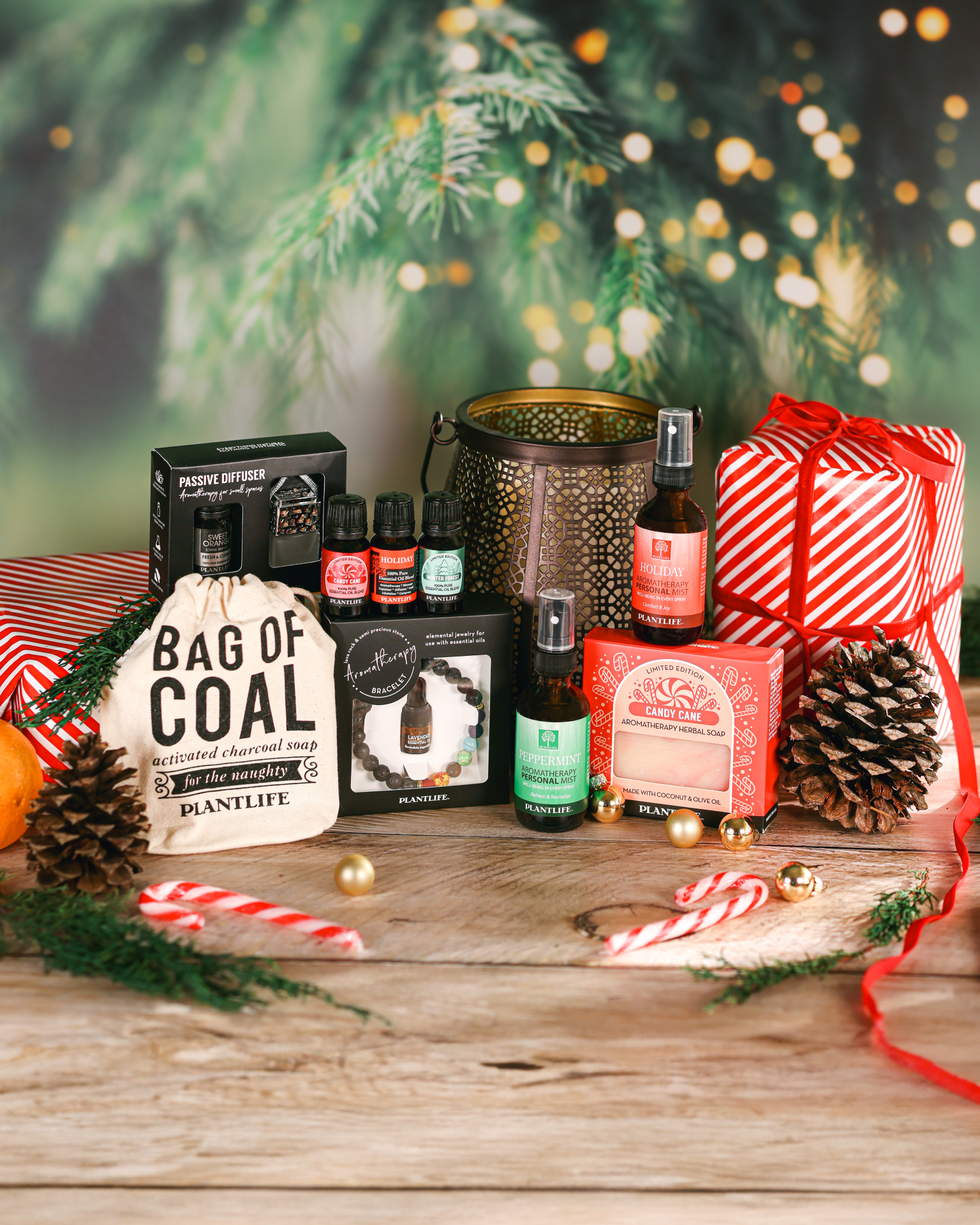 Collection of Christmas-themed products including bottles, a bag labeled 'Bag of Coal', and a gift box on a wooden surface with festive decorations.