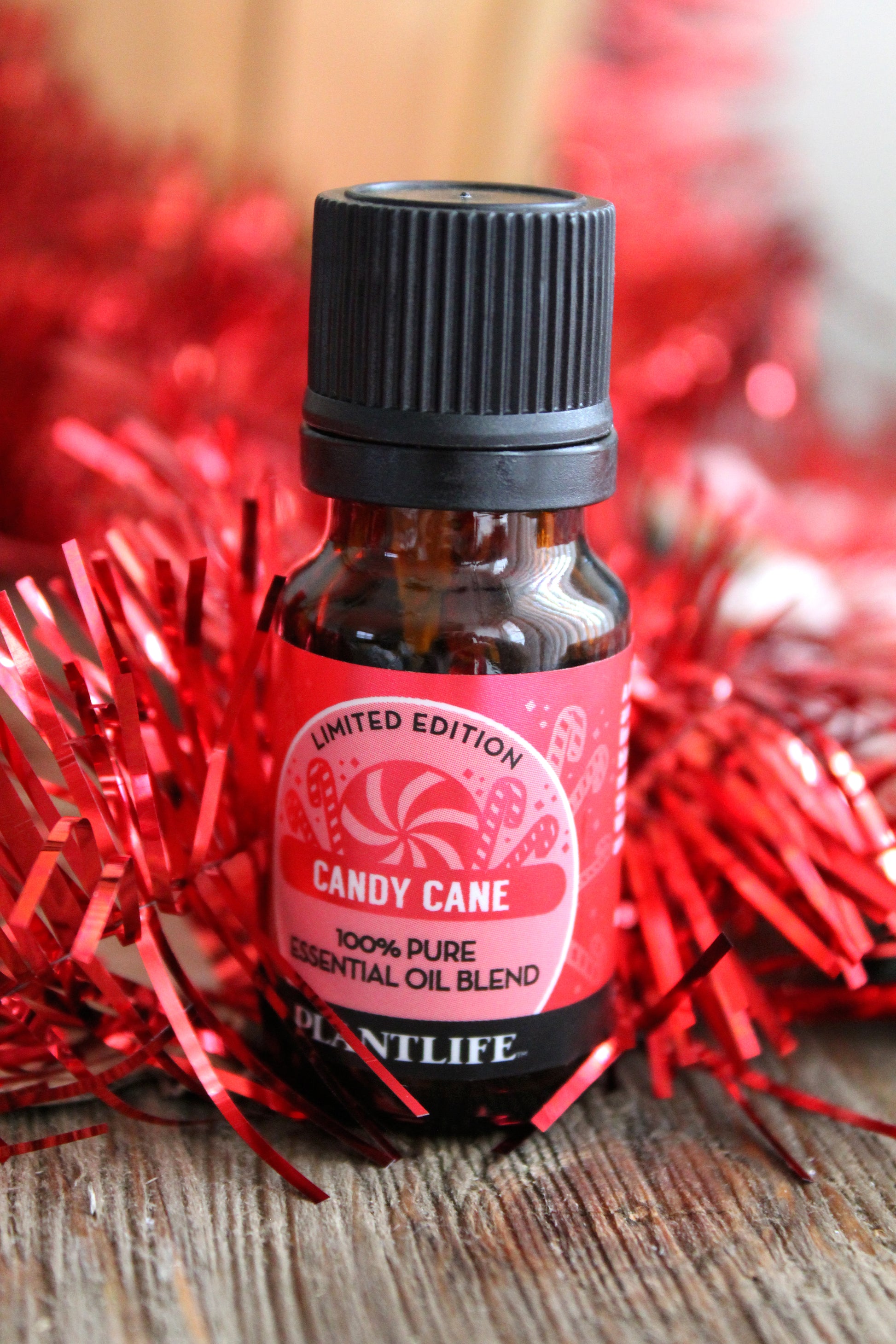 Essential oil bottle labeled 'Candy Cane' with red tinsel in the background