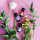 Plantlife Essential Oils with Florals – Aromatherapy Bottles Styled with Flowers on Pink Background for Natural Beauty and Wellness