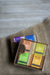 Box of Plantlife soap bars with various scents on a textured surface