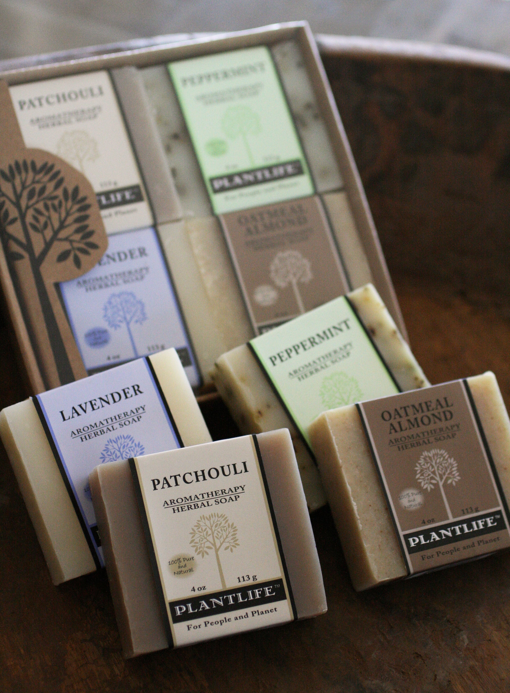 Collection of Plantlife soap bars with various scents in a wooden box.