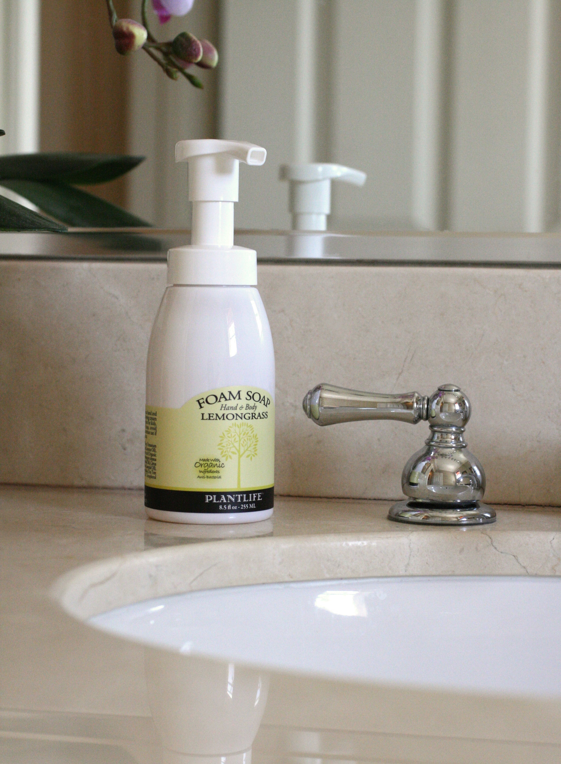 Foam soap bottle on a bathroom counter with a sink and faucet in the background