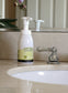 Foam soap bottle on a bathroom counter with a sink and faucet in the background