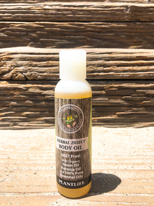 Bottle of Herbal Insect Body Oil by Plantlife on a wooden surface with a wooden background