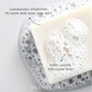 Plantlife bar soap shown on a bed of foamy bubbles, featuring a creamy white color with thick, airy lather. Text highlights its luxuriously hydrating formula designed to leave skin silky and soft, with rich lather for a clean, gentle wash.