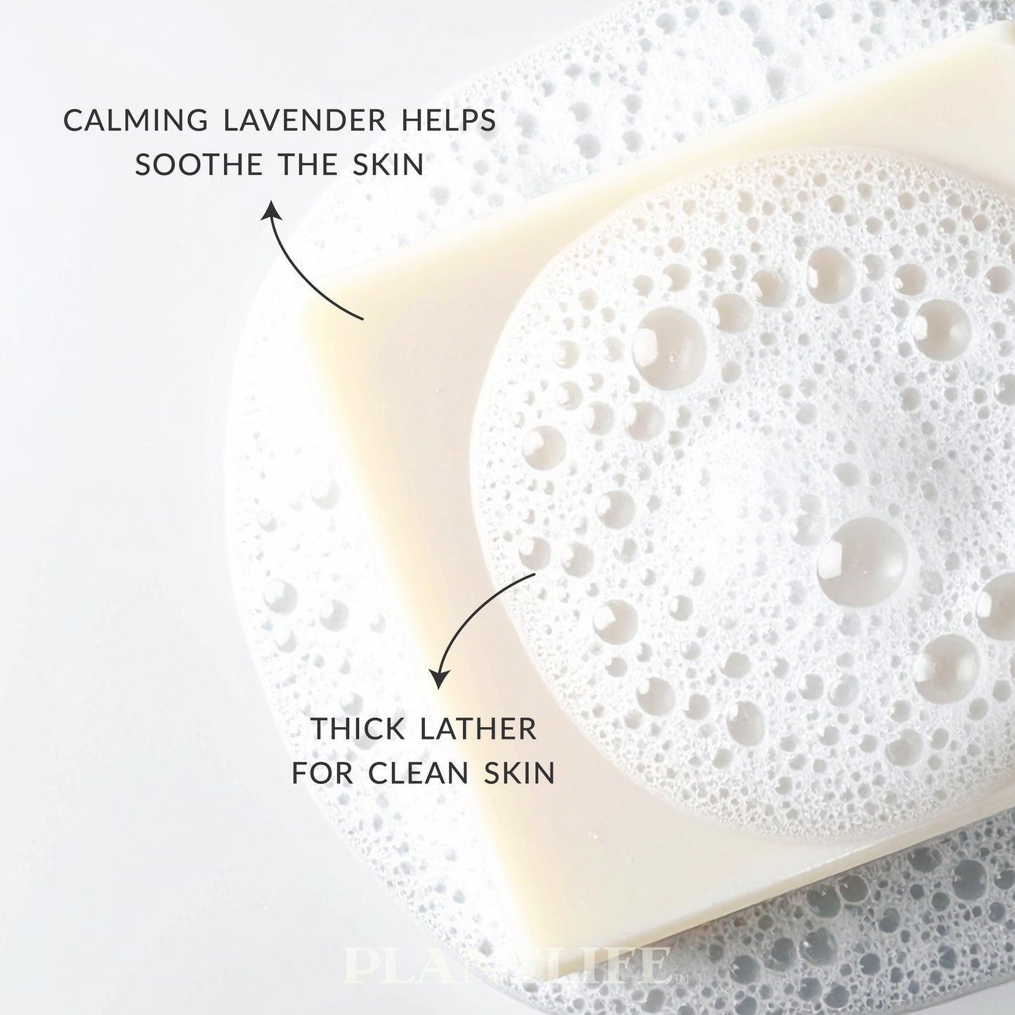 Lavender Soap bar with foam on a textured surface, labeled for calming lavender and thick lather.