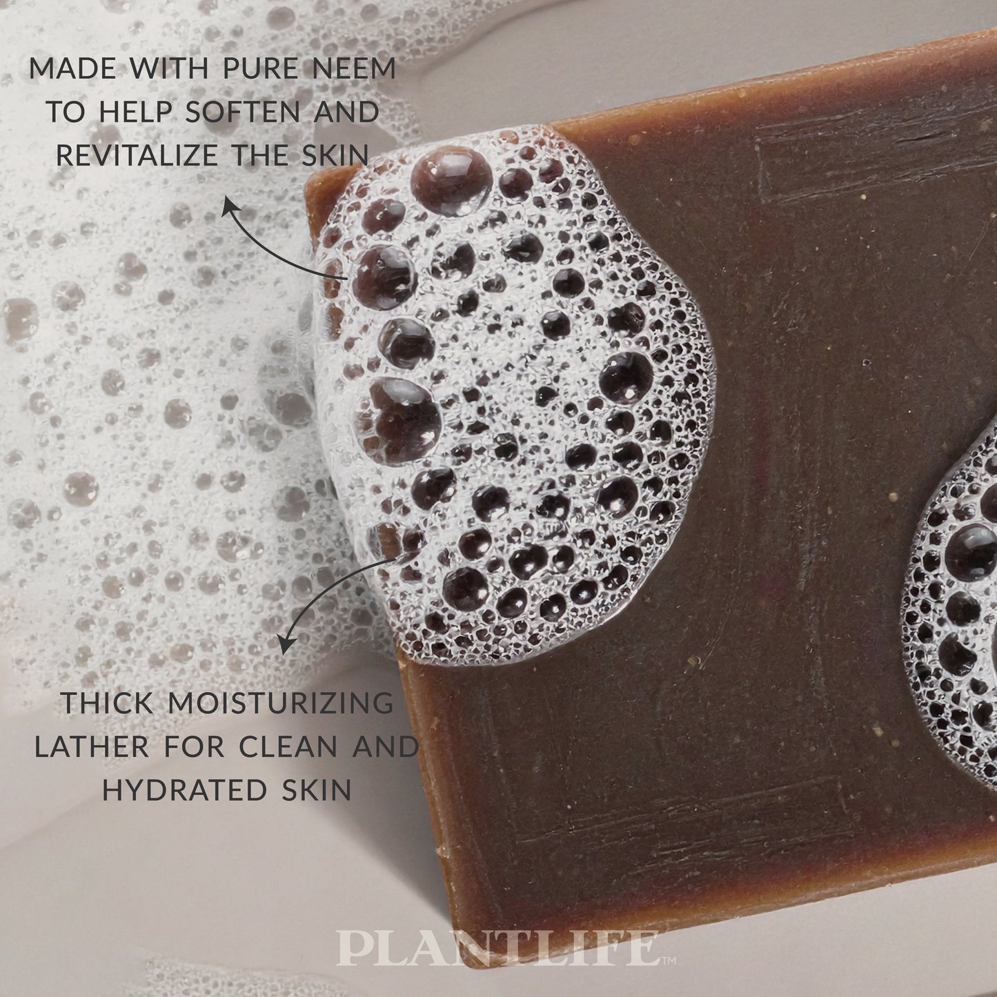 Bar of soap with foamy lather on a neutral background, featuring text about its benefits.