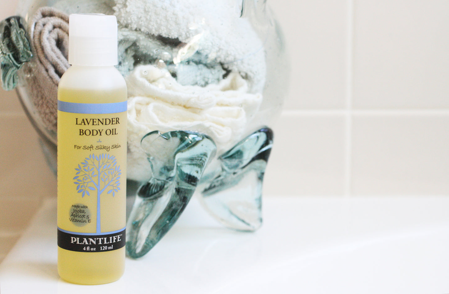 Bottle of lavender body oil with a towel in the background
