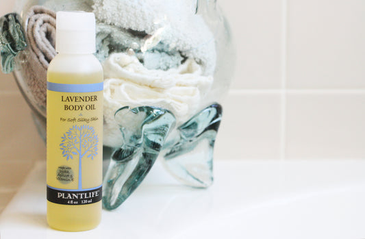 Bottle of lavender body oil with a towel in the background