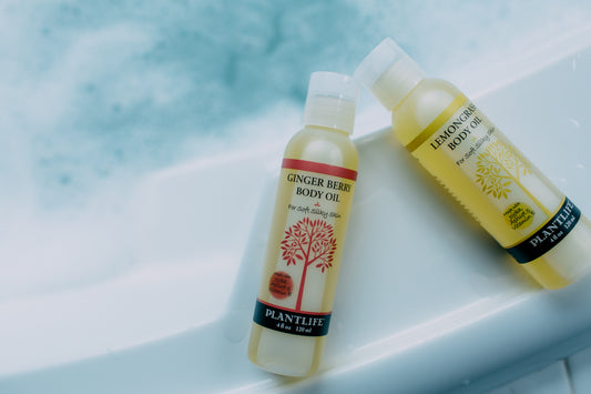 Two bottles of Plantful body oil on a light blue background