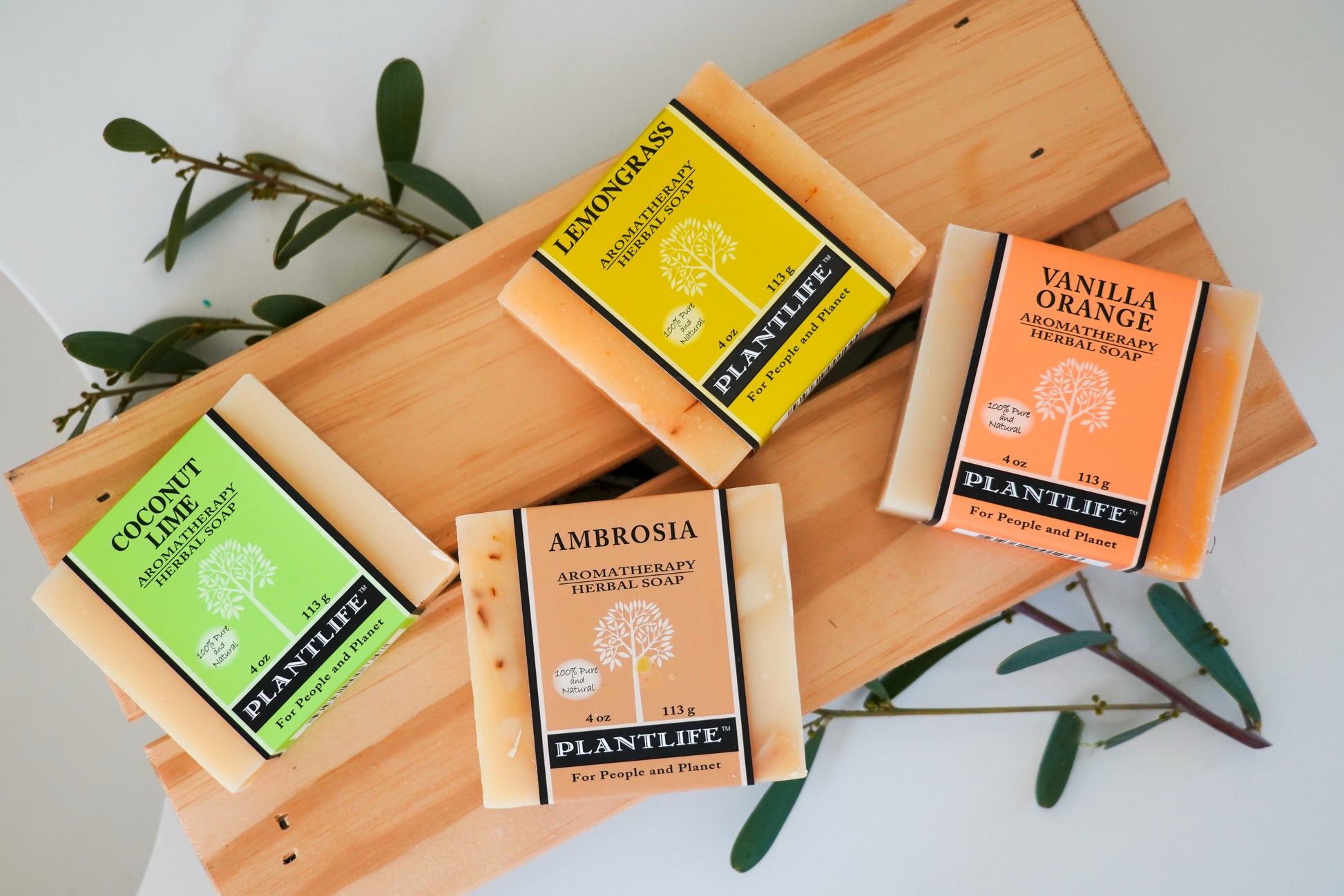 Collection of Plantlife aromatherapy products on a wooden tray with greenery.