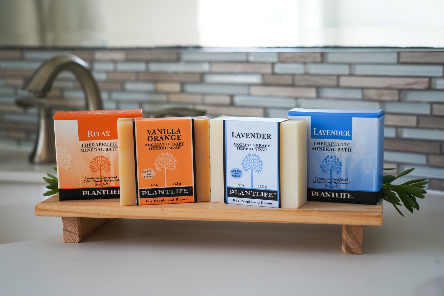 Plantslife soap bars on a wooden stand with a tiled backsplash in the background