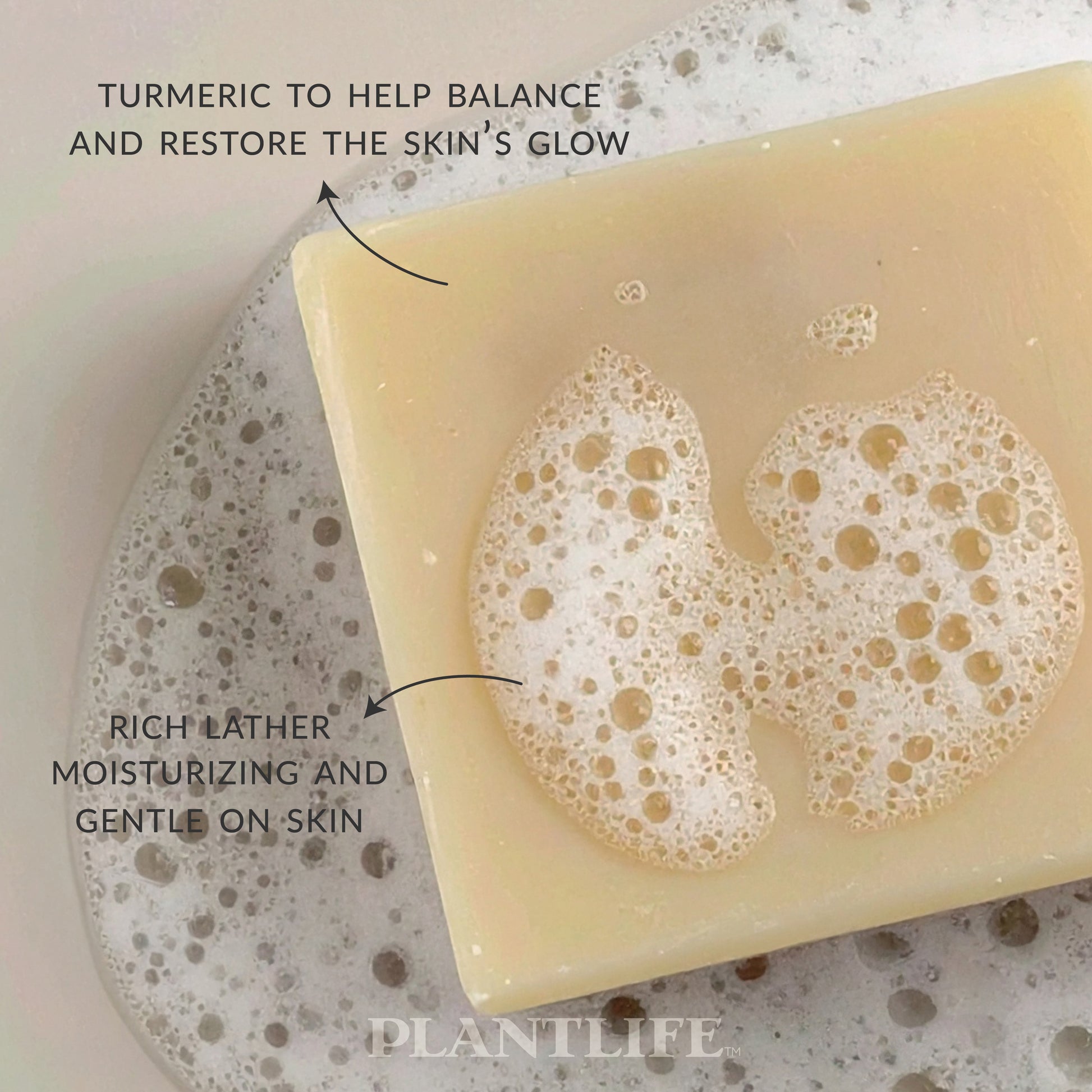 Close-up of a creamy yellow Plantlife soap bar resting in foamy water. Text on the image highlights “Turmeric to help balance and restore the skin’s glow” and “Rich lather, moisturizing and gentle on skin.”