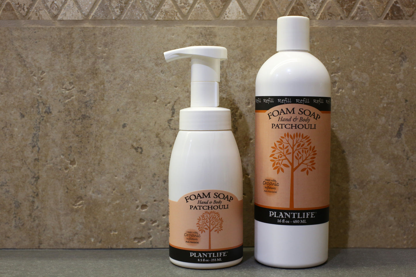 Two bottles of Plantlife Foam Soap on a bathroom counter with a tiled wall background.
