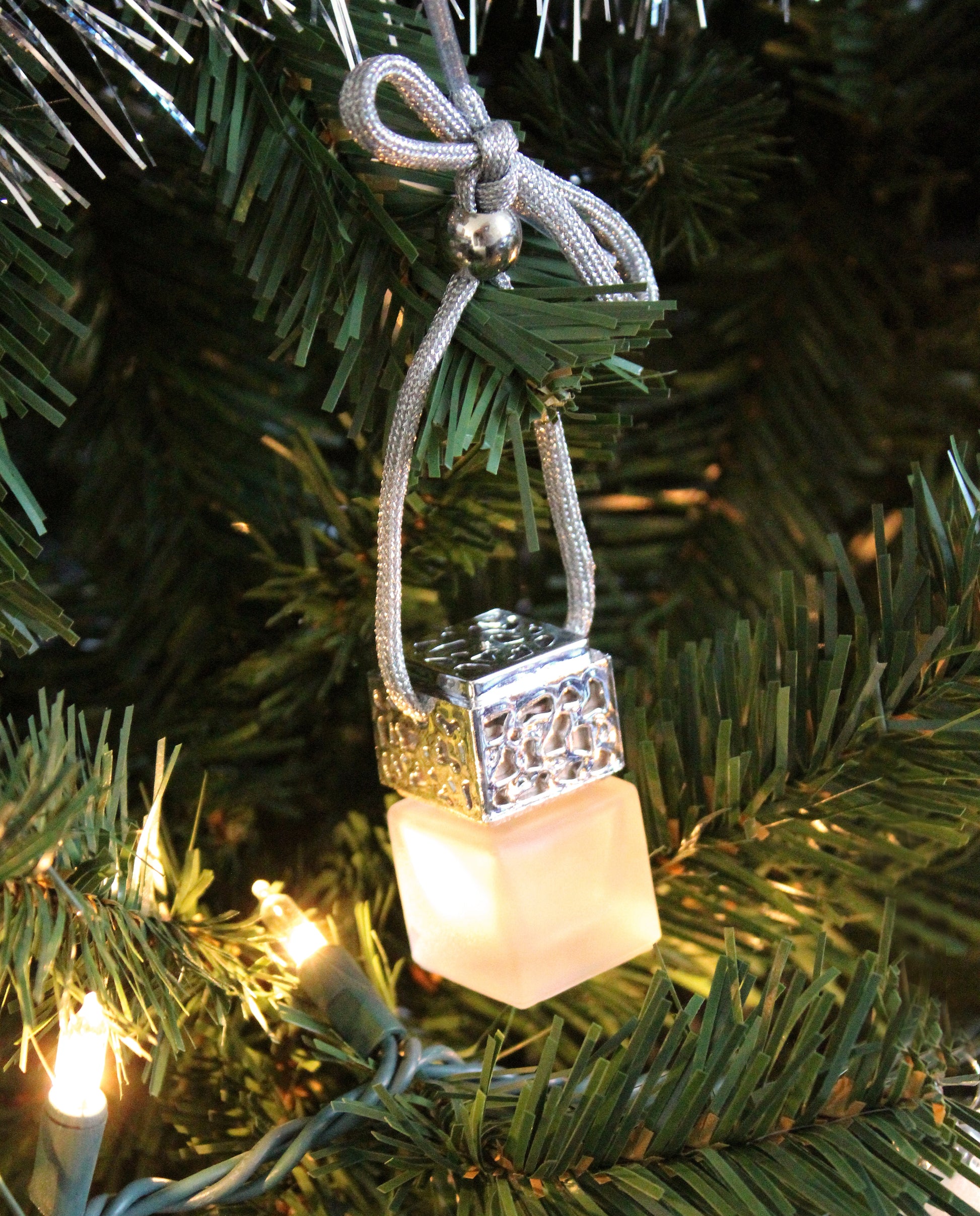 Silver Passive Diffuser by Plantlife hanging on a Christmas tree – festive essential oil air freshener ornament.
