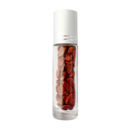 Clear glass essential oil roller bottle with a white cap, filled with polished red gemstone chips inside.